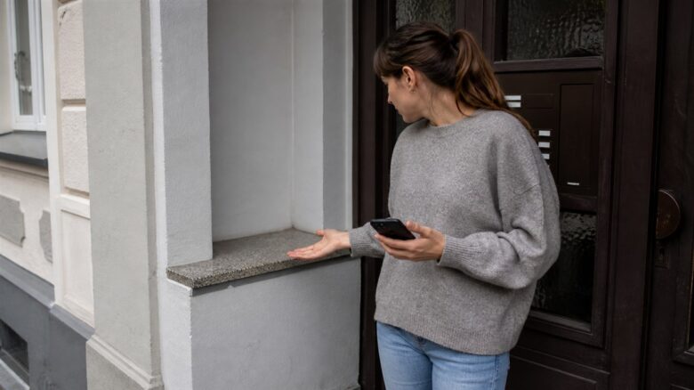 Empfängerin prüft nach Zustellmeldung einen leeren Ablageort am Hauseingang